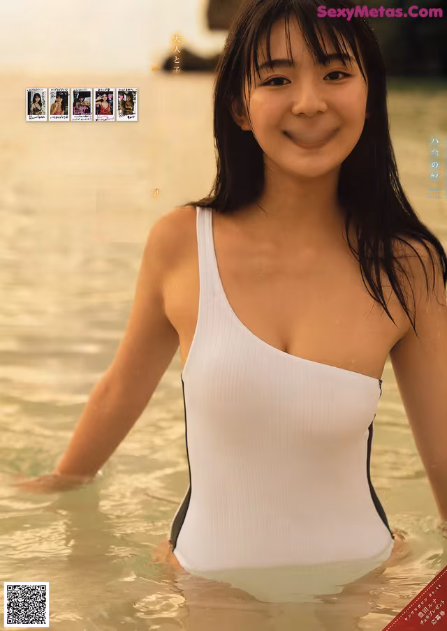 A woman in a white bathing suit standing in the water.