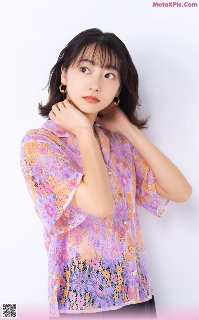 a woman wearing a purple shirt and black pants