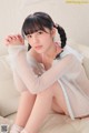 A woman sitting on top of a white couch.