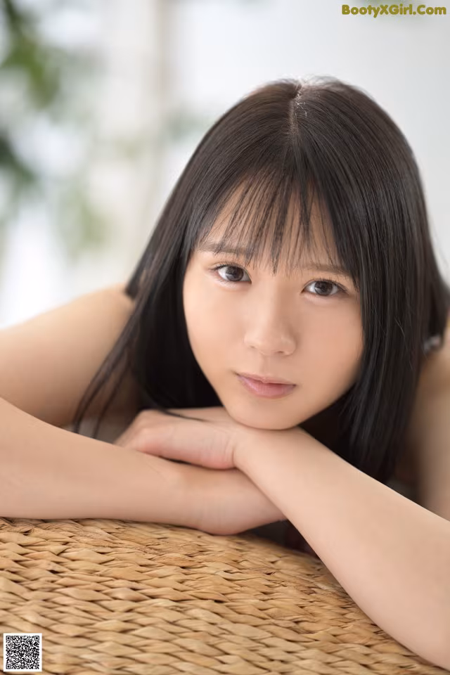 A young woman laying on top of a wicker basket.
