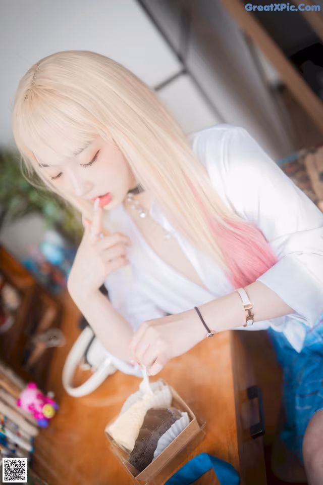 A woman sitting at a table eating a piece of cake.