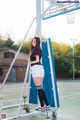 A woman standing on top of a basketball court next to a ladder.