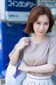 A woman in a gray shirt and white skirt posing for a picture.