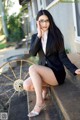 A woman in a business suit sitting on the steps of a building.