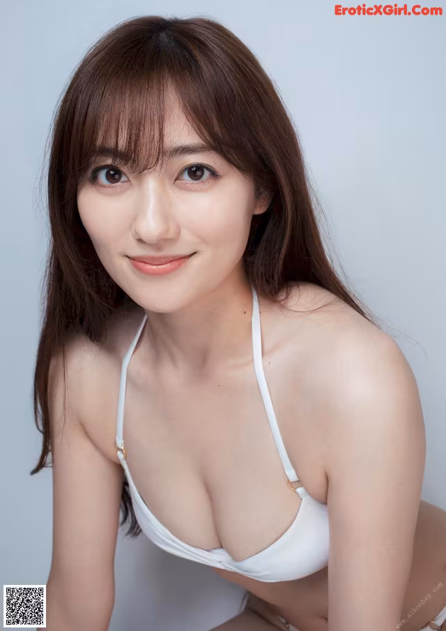 A woman in a white bikini posing for a picture.