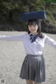 A woman in a school uniform with a suitcase on her head.