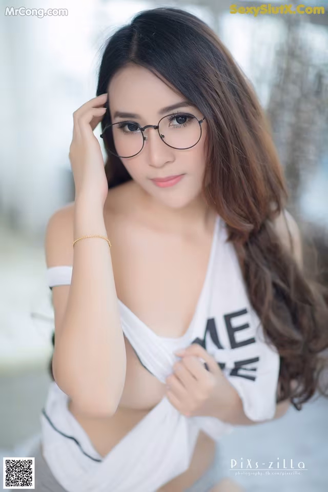 A woman wearing glasses and a white shirt.