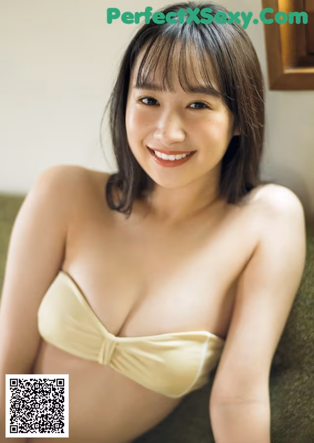 A woman in a yellow bikini posing for the camera.