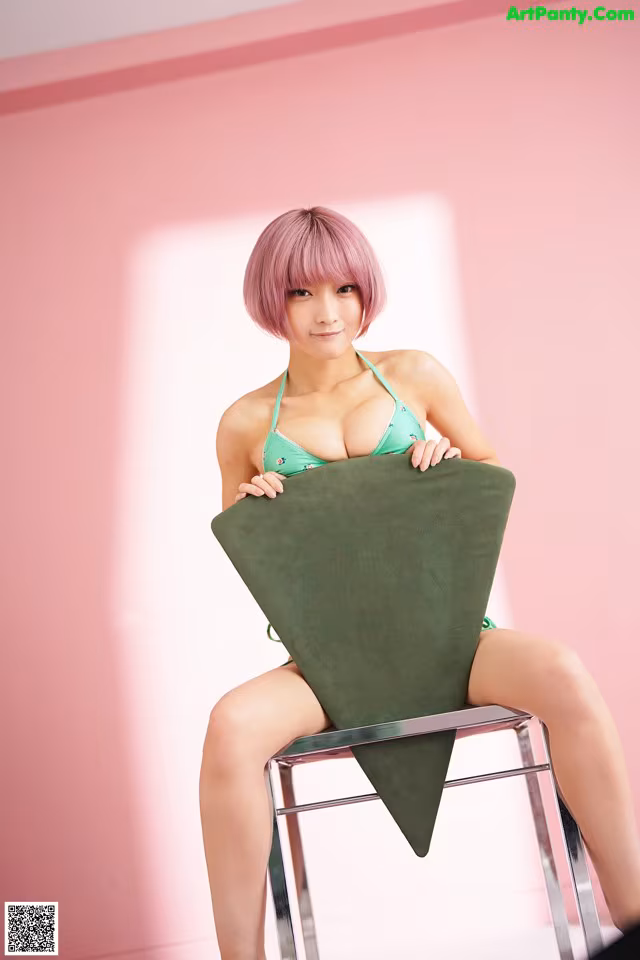 A woman in a green bikini sitting on a chair.